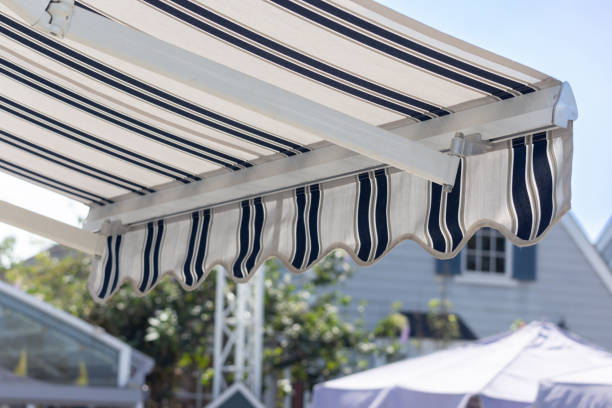 A blue and white striped awning is over a patio