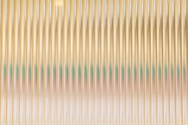 A row of glass panels with a green stripe. The panels are arranged in a way that creates a sense of movement and depth. Scene is one of elegance and sophistication