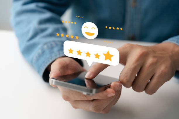 istock Satisfaction survey, customers use smartphones to rate their experience with five stars. 2201092999