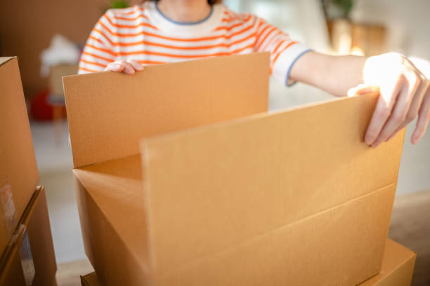 istock Young woman cheerfully unpacking boxes in her new apartment during relocation 2201093211