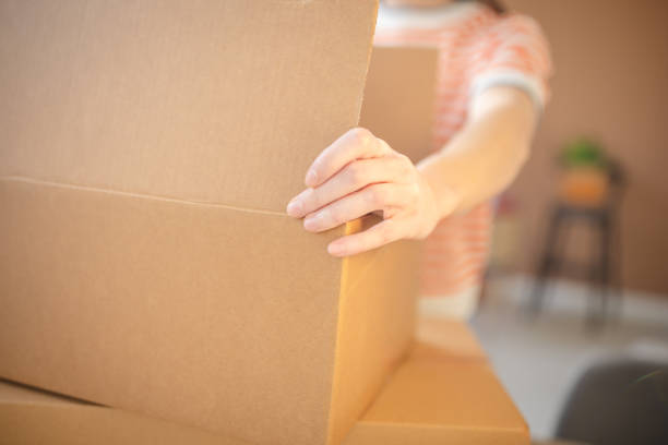 istock Young woman happily unpacking boxes in her new apartment during the exciting move-in process 2201093286