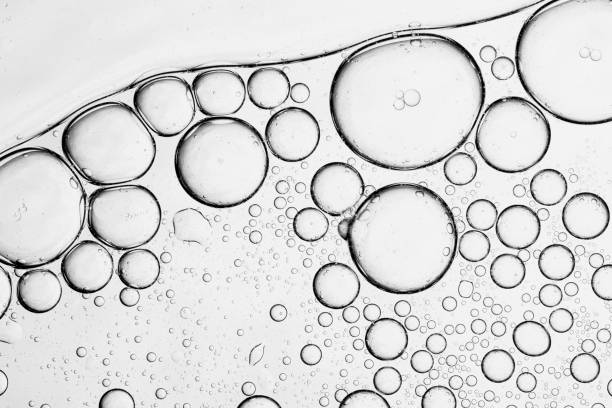 istock Macro bubbles,Effervescent fizz and clean cosmetics hygiene or rejuvenate renewable energy. Studio shot of transparent cosmetic blue gas bubbles under water in full-frame macro close up with selective focus blur. 2201094867