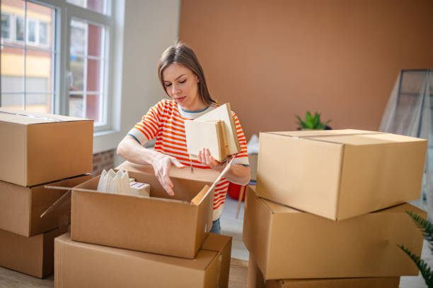 istock Young woman joyfully unpacks boxes in her new apartment while beginning a fresh chapter in her life 2201095709