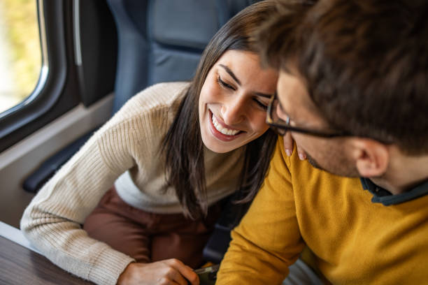 istock Young couple embracing while traveling by train 2201096125