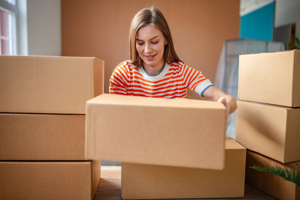 istock Young woman joyfully unpacking boxes in her new apartment while embracing a fresh start in life 2201097348