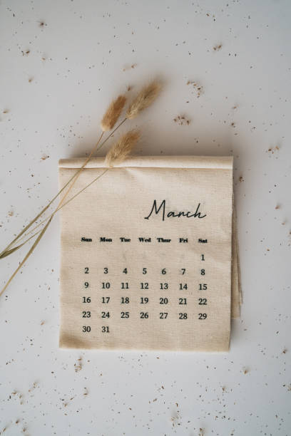 istock Beige linen fabric calendar with March month 2025 on a white background with copy space. Flat lay, template. Minimal top view aesthetic composition. Stylish, trend concept. Parisian vibes. 2201097626