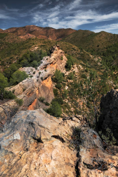 istock landscape of Rocky Cliffside Path Overlooking Lush Green Valley with Expansive Sky View 2201097743