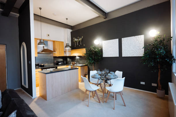 Modern open-plan kitchen and dining area with stylish furnishings and contemporary decor features neutral tones and indoor plants