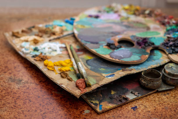 istock An old palette with oil paints in the artist's studio. Painted background created by a creative person. 2201100439