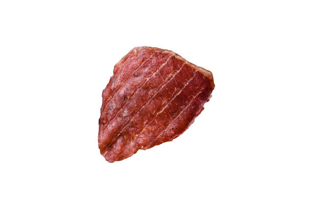 Jerky, dried pork meat slices with salt and spices on a white background