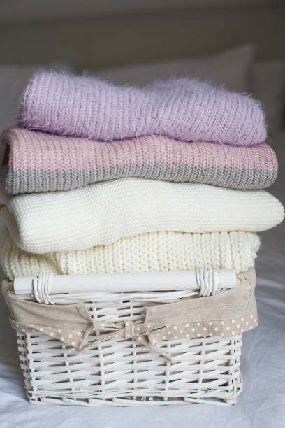 istock Basket with clean things on the bed. Cozy. Knitted sweaters. 2201102469