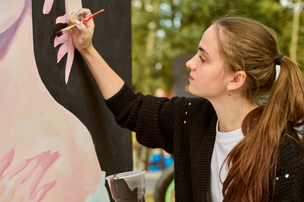 istock Young female artist painting outdoors in bright daylight 2201103273