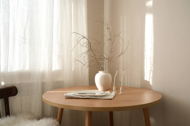 istock A serene minimalist setup with a wooden table, stylish plate, elegant vase with dry branches and natural decor accents enhancing the ambiance 2201107804