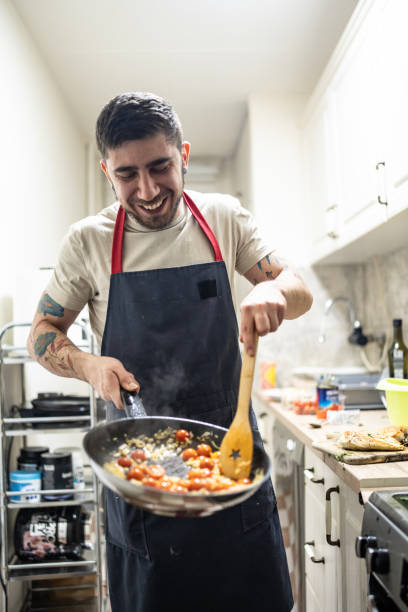 istock Smiling Chef Cooking Fresh Ingredients in a Cozy Kitchen 2201109639