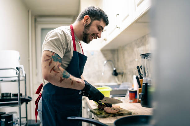 istock Young Man with Tattoos Cooking with Passion in a Domestic Kitchen Setting 2201109651