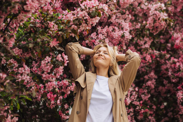 istock Relaxed young woman surrounded by blossoming apple trees enjoying spring time and happiness 2201110015
