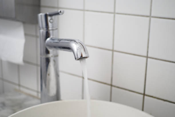istock Fresh water is flowing gracefully from a sleek, shiny chrome faucet in a cozy kitchen setting, 2201110702