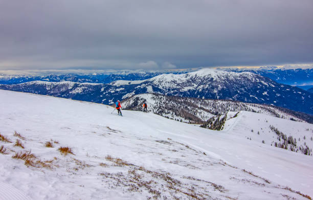 Skiers Enjoying Snowy Alpine Mountain Slopes
