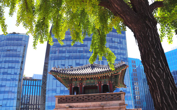 Past and Present, contrast in architecture concept. Ancient pavilion against the background of modern buildings, Seoul, South Korea. Topic of summer travel, trip abroad on vacation, cruises and tours