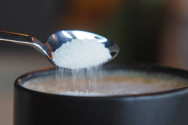 istock white sugar pouring from a in a paper packet on a coffee cup 2201112409