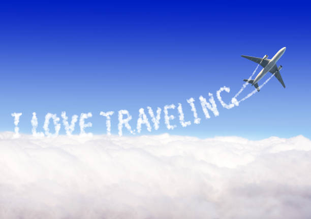 istock Blue sky with aircraft and Jet trailing smoke. Horizontal banner with airplane drawing a word I love traveling in sky. Topic of summer holiday, travel, trip abroad on vacation, cruises and tours 2201112756