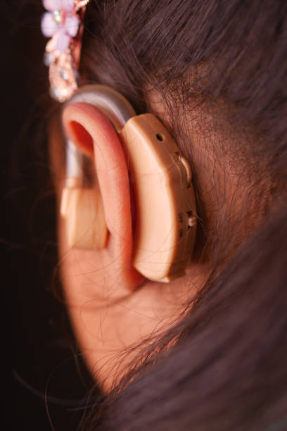 istock Hearing aid concept, little girl with hearing problems. 2201112774