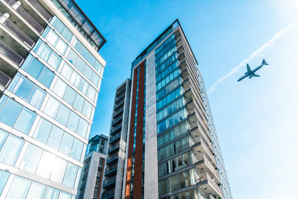 Airplane flying over modern buildings in london, uk