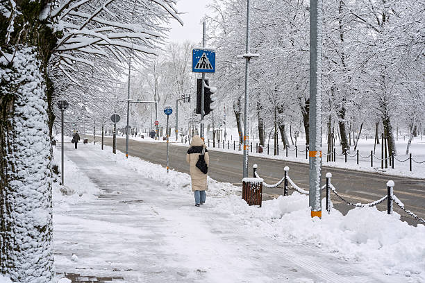 City street with pedestrian walking, weather conditions snowfall. photographed from a medium height angle