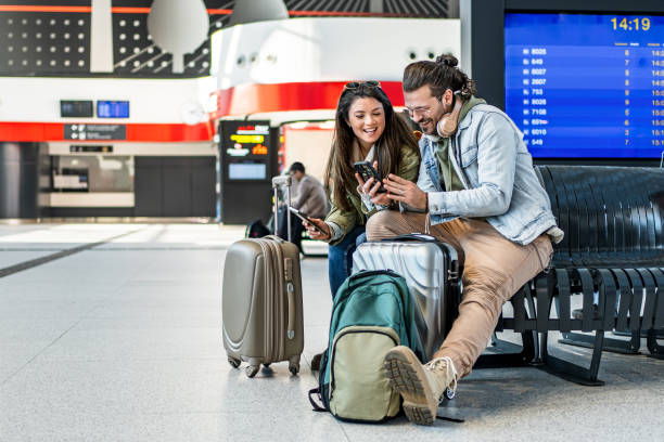 istock Couple using phone at the train station 2201122045