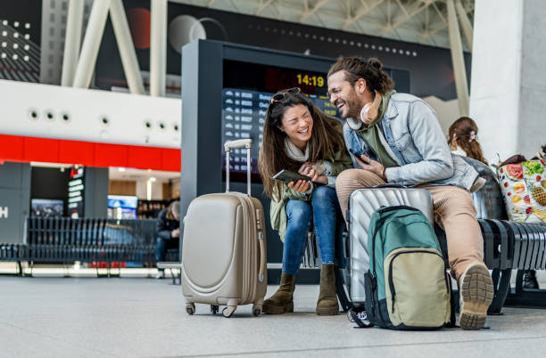 istock Couple using phone at the train station 2201122063