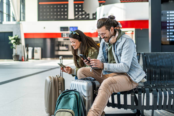 istock Couple using their phones at the train station 2201122082