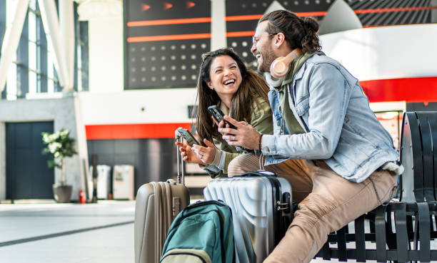 istock Husband and wife passengers using their smartphones at the train station 2201122337