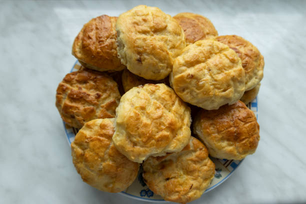 istock Homemade golden brown scones on a plate on a marble surface. 2201122511