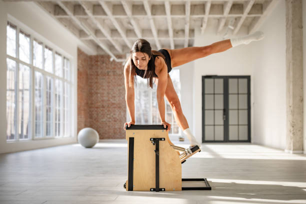 istock Young woman practices pilates with focus and determination in a modern studio setting 2201124719