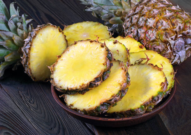 istock ripe pineapples on a wooden table. close up 2201128114