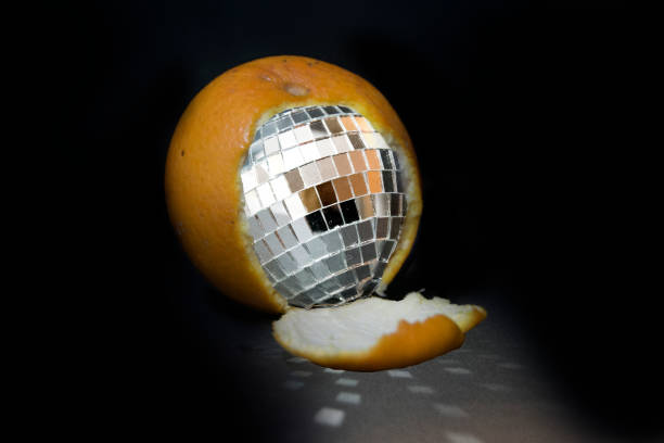 istock Creative surreal image of an orange partially peeled to reveal a disco ball inside 2201133061