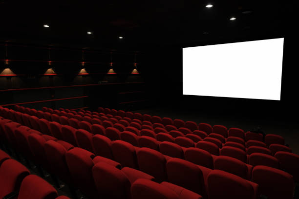 istock Empty cinema interior with rows of red seats facing a large white screen ready for a movie experience 2201138746
