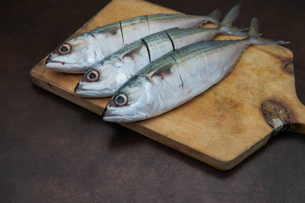 istock Some Fresh Mackerel Fish On Wooden Chopping Board 2201139475