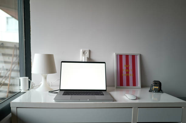 Clean and organized home office workspace with a laptop featuring a blank screen, perfect for displaying your content