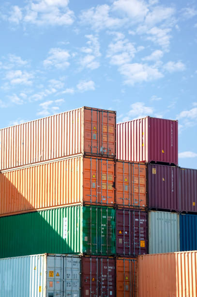 istock Shipping containers stacked against blue sky 2201144667