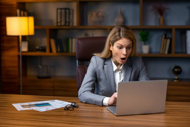 istock Shocked young business woman using laptop looking at computer screen blown away in stupor sitting in office. Human face expression, emotion, feeling, perception, body language, reaction 2201149485