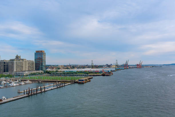 istock Skyline view of a bustling harbor with container cranes and marina on a cloudy afternoon 2201151557