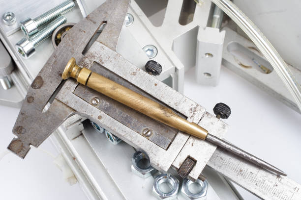 Vernier caliper and screwdriver on industry machinery background