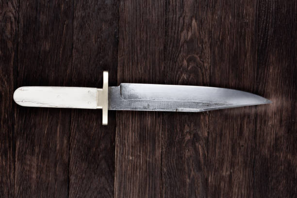 Old west bowie knife on wooden deck background