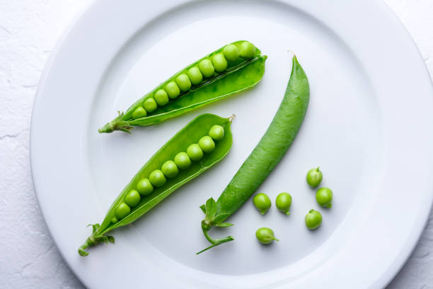 istock Green sugar snap peas placed on a white plate 2201153979