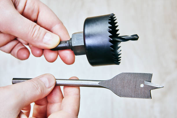 istock Hand holding hole saw and spade drill bit. 2201154889
