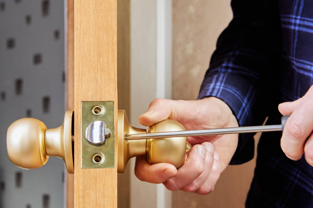 istock Door installer secures handle and latch to interior door using hand screwdriver. 2201154914