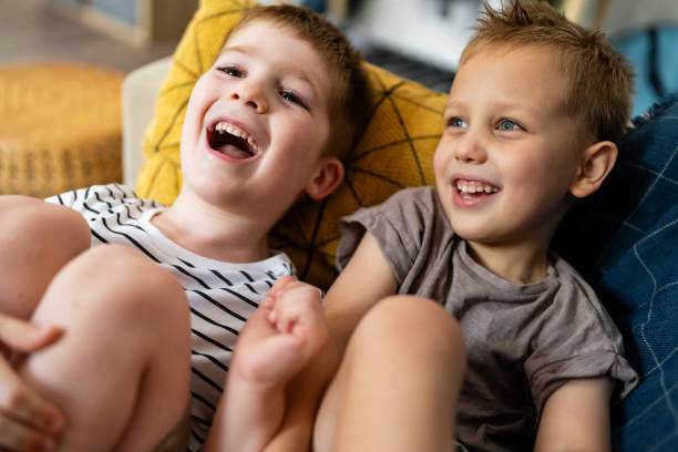 istock Joyful siblings laughing together at home on a cozy afternoon 2201155880