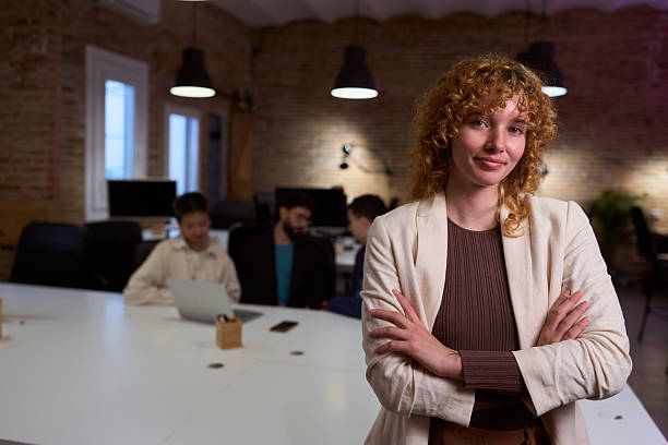 istock Confident young businesswoman smiling with folded arms in modern office 2201156363