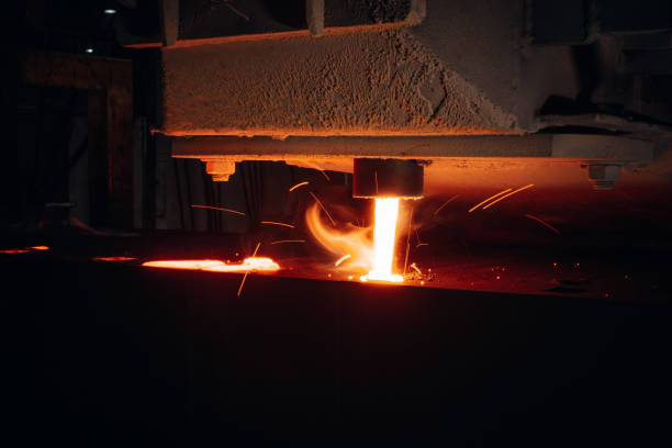 istock Molten metal pours into a mold sparks flying in a dark industrial setting 2201157575